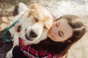 Young girl hugging Great Pyrenees dog