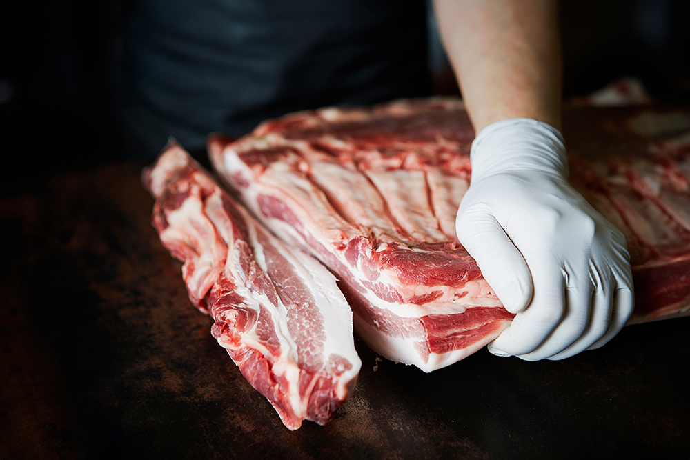 person cutting pork ribs