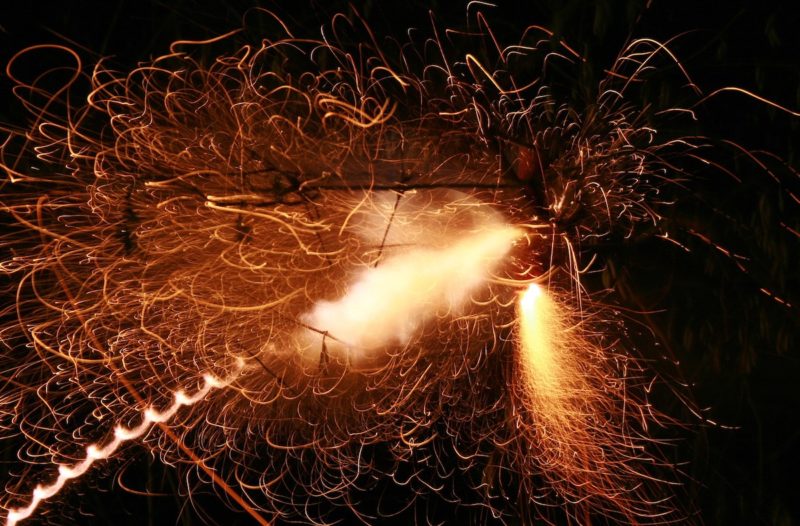 firecracker exploding in the air with lots of orange sparks